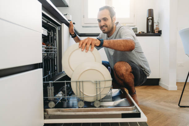 istock Man emptying the dishwasher in a modern kitchen 2164405117