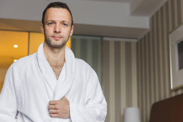 istock Young Caucasian man in white cotton bathrobe 2164405707