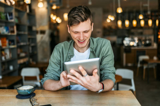 istock Young Man with Tablet in Contemporary Bookstore 2164405777