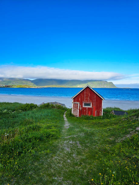 istock Charming Red Cabin Overlooking Tranquil Waters in Norway Under a Clear Blue Sky, Lofoten 2164410437