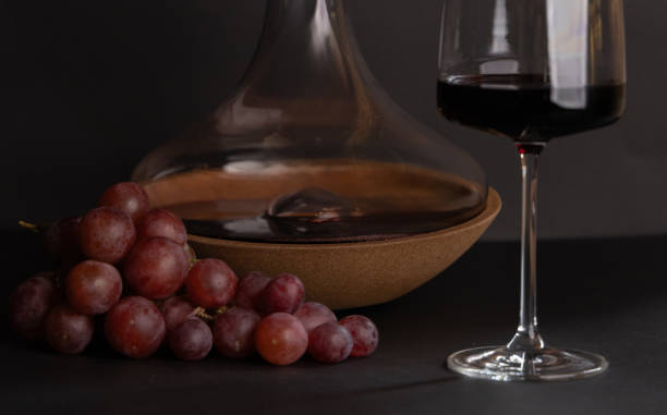 istock wine in glass and grape, decanter and bottle as decoration on black backdrop.static composition for winery,wine production businesses. 2164413274