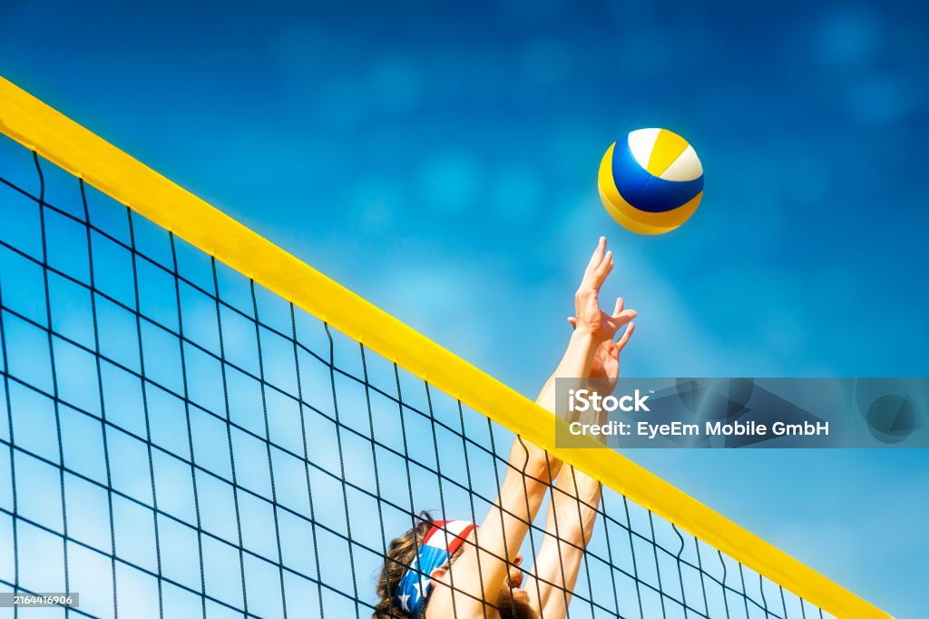 Low Angle View Of Man Playing Volleyball Against Blue Sky - Royaltyfri Strandvolleyboll Bildbanksbilder Low Angle View Of Man Playing Volleyball Against Blue Sky - Royaltyfri Strandvolleyboll Bildbanksbilder