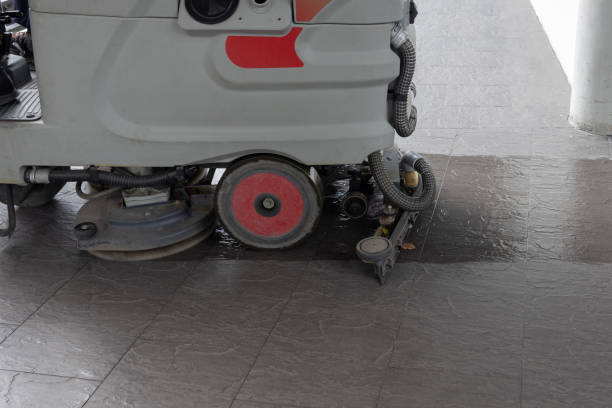 A cleaning machine with a red wheel is being used to clean a floor