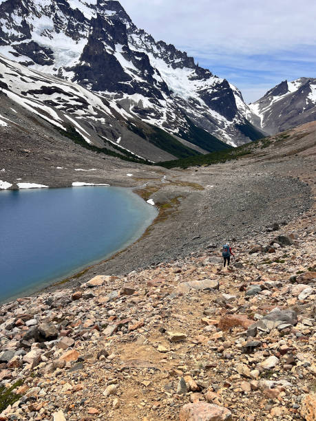 istock Backpacker hikes above lake and mountains 2164419390