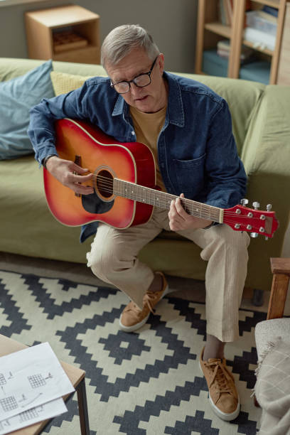 istock Mature Man Playing Guitar Singing 2164427114