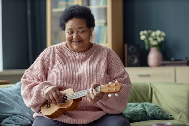istock Mature Black Woman Playing Ukulele Smiling 2164427120