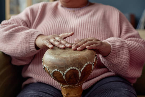 Black Mature Woman Playing Traditional Drum