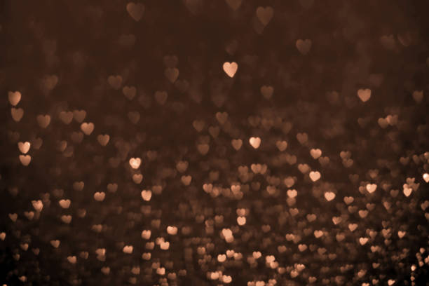 peach color hearts, sparkling glitter bokeh background, valentines day abstract defocused texture. Holiday romantic lights
