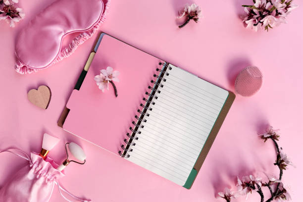 istock Square pink overhead background, quality of sleep, and self care routine. Sleeping mask, blank notebook with copy-space, massage stone roller. 2164435649