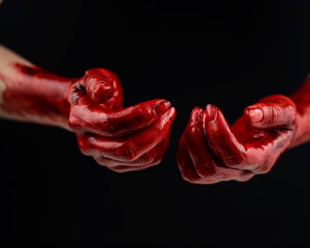 istock Women's hands in blood on a black background. 2164451721