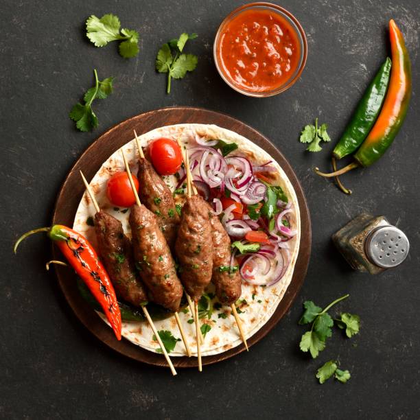 istock Lula kebab with vegetables on flat bread on wooden platter 2164457131