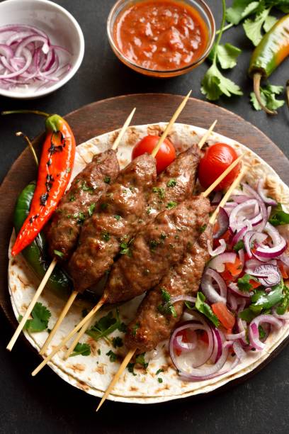 istock Lula kebab with fresh vegetables on flat bread on wooden platter 2164457136