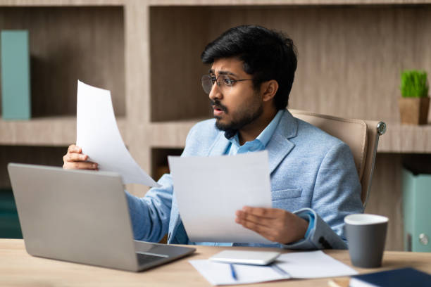 istock Concerned Indian Businessman Holding Papers Having Problems With Bills Indoor 2164474029