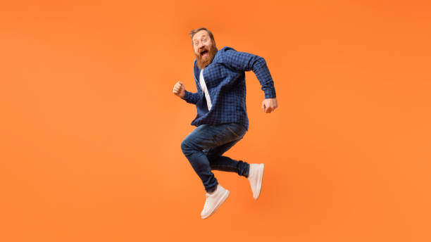 istock Joyful man with beard jumps and shouting in excitement, studio 2164475928