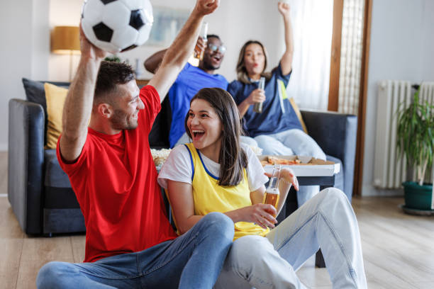 istock Excited fans shouting while watching soccer on TV 2164477525