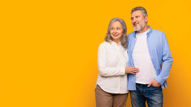 istock Happy senior couple hugging looking aside at empty space, studio 2164478137