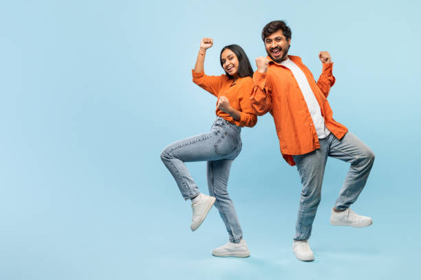 istock Happy couple dancing joyfully on blue background 2164484675