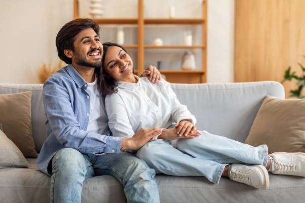 istock A Man and a Woman Sitting on a Couch, Hugging 2164487301
