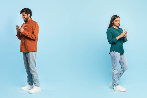 istock Man and woman standing apart using phones 2164487507