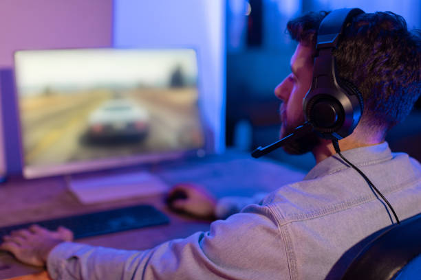 istock Man gaming on PC in a dimly lit room 2164489355