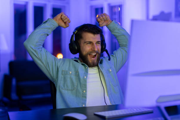istock Gamer celebrates a win with raised arms 2164489411