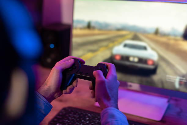 istock Focused millennial playing a racing game at home 2164489445