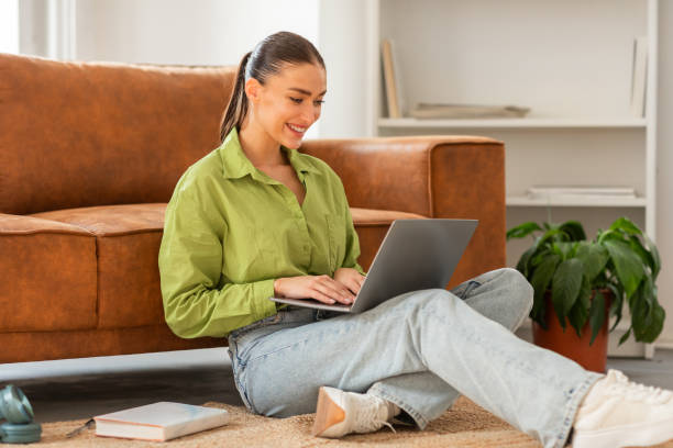 istock Woman Sitting on Floor Using Laptop, Working from Home 2164491437