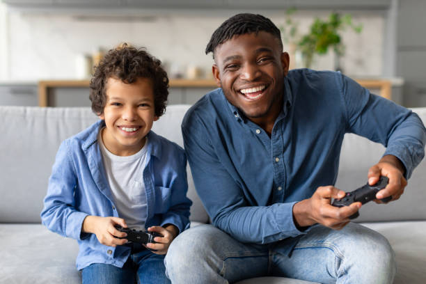 istock Father and son laughing while playing video games 2164492196