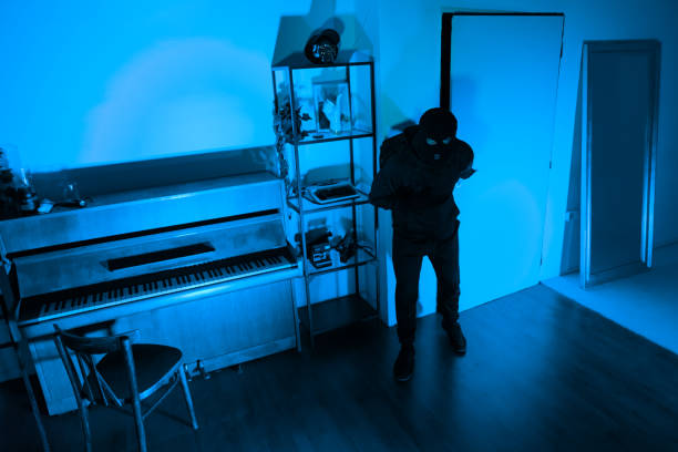 istock Burglar with full backpack examining dark room 2164493448