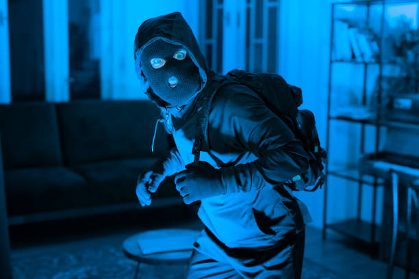 istock Intruder tiptoeing silently in a dark room 2164493469