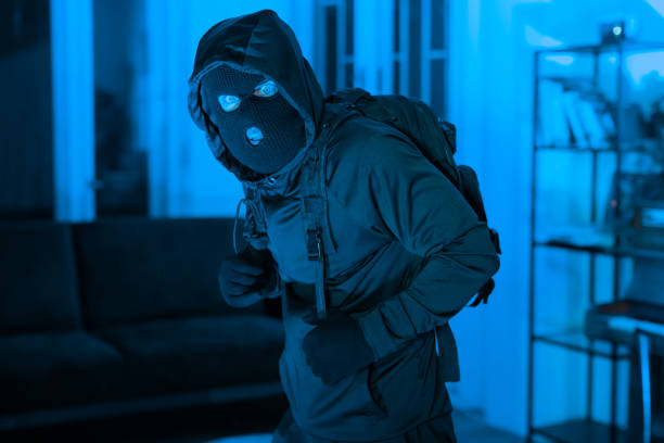 istock Masked man burglar ducking and hiding indoors 2164493475
