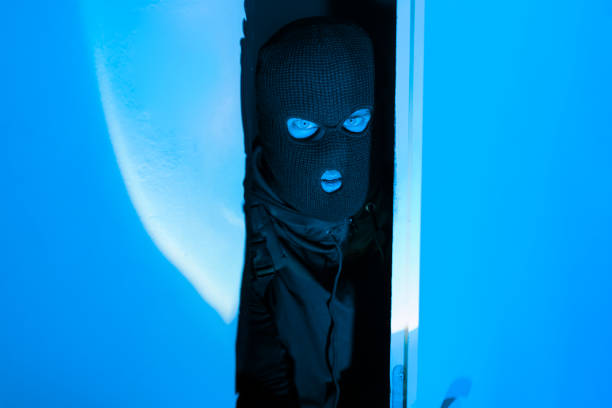 istock Masked intruder man peeking inside room suspiciously 2164493494