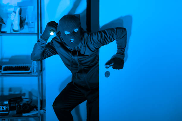 istock Burglar with flashlight during a night heist 2164493496