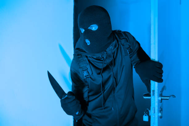 istock Armed burglar sneaking into a room at night 2164493502