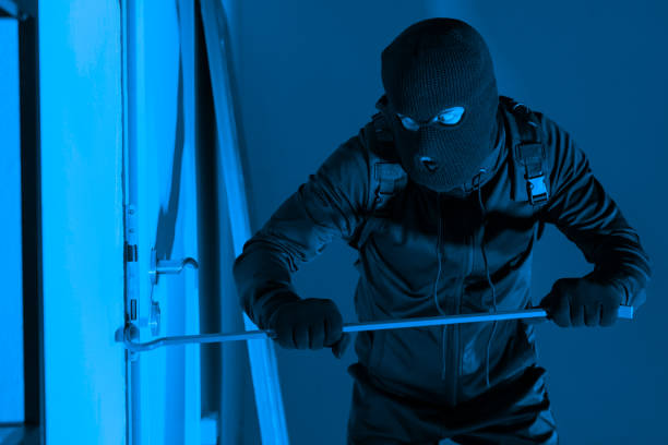 istock Intruder using crowbar to force door open at night 2164493504