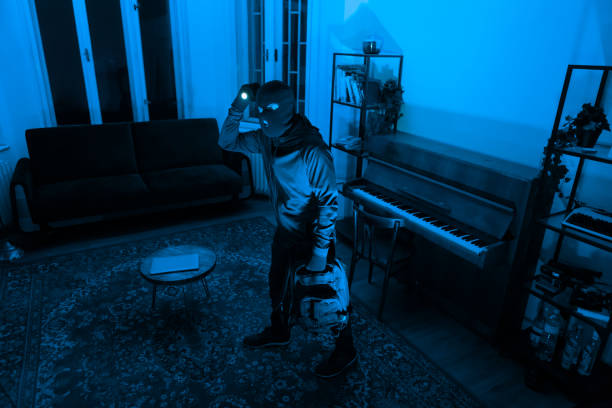 istock Burglar with flashlight in dark room, break in 2164493536