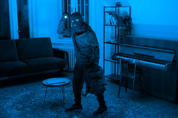 istock Silhouette of a thief in a lit room 2164493545