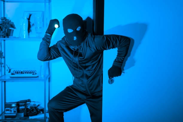 istock Silhouette of a stealthy thief with flashlight 2164493553