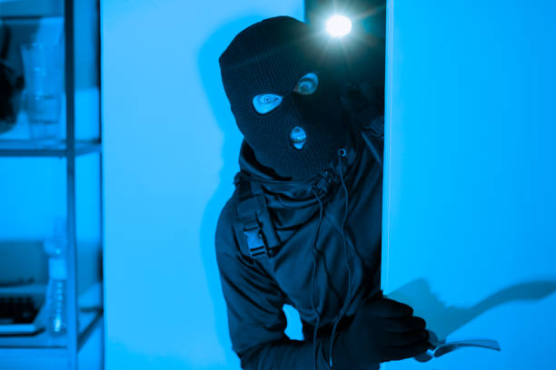 istock Burglar with crowbar breaking into a house 2164493554