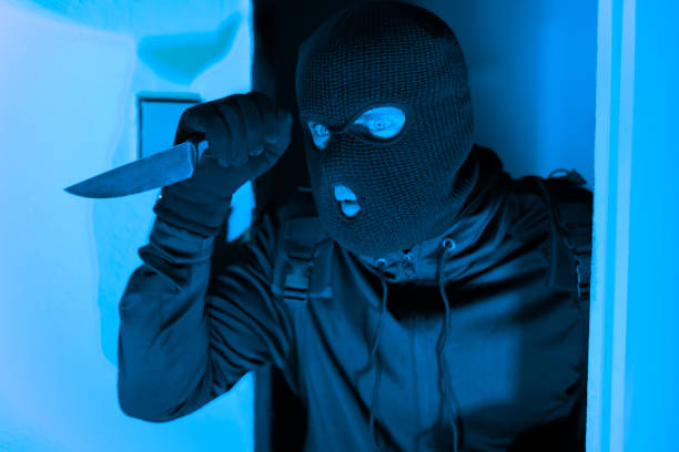 istock Masked thief peeking around door, break in 2164493562