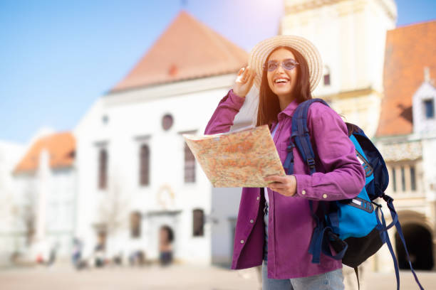 istock Tourist young woman with map and backpack 2164495909