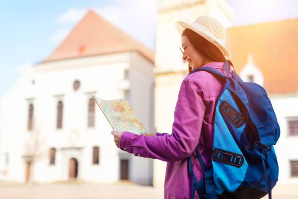 istock Woman holding map in square with sunlight flares 2164495978