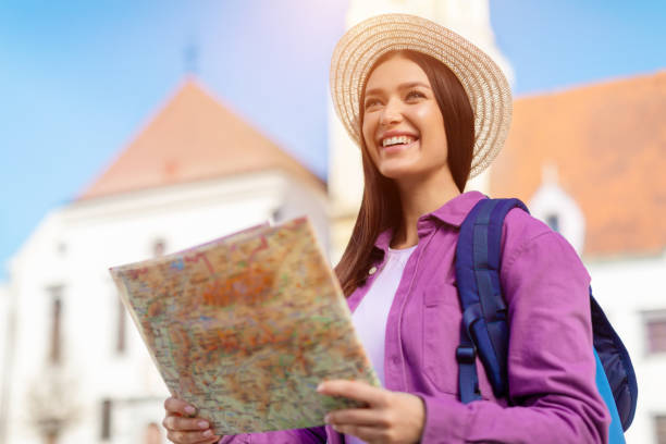 istock Tourist woman reading a map with excited expression 2164495987