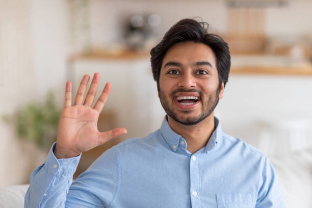 istock Happy Man Waving Hello in a Casual Setting 2164497695