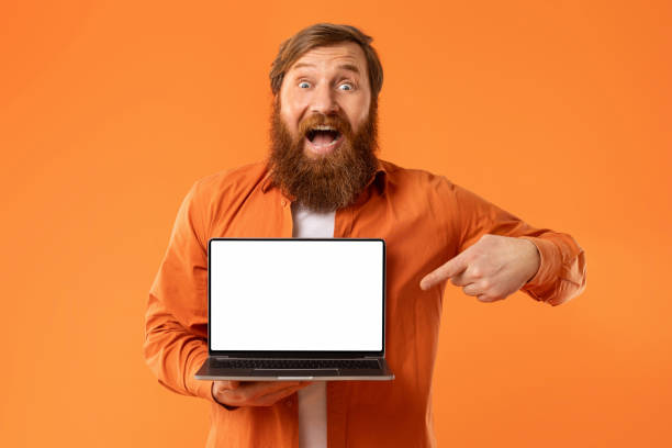 istock Happy Redhaired Bearded Freelancer Man Showing Laptop Empty Screen, Studio 2164497841