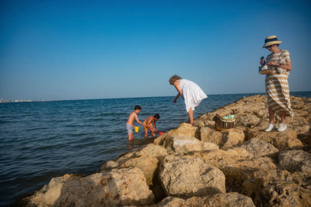 istock Family exploring rocky beach area on a sunny day 2164498693