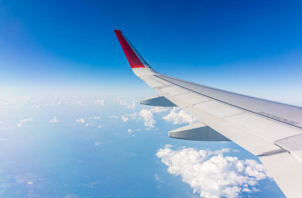 istock View from the airplane window at a beautiful cloudy sky and the airplane wing 2164499094