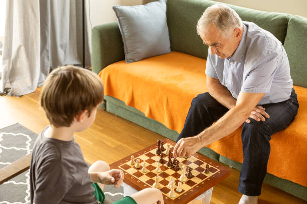 istock 6 year old boy playing chess with his grandfather 2164499098