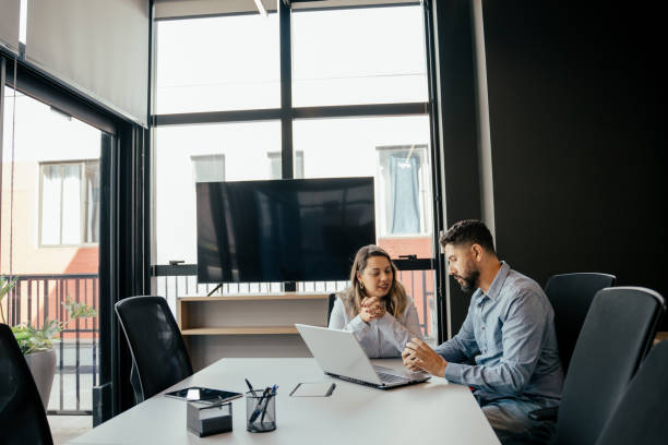 istock Two coworkers talking in the office 2164499347