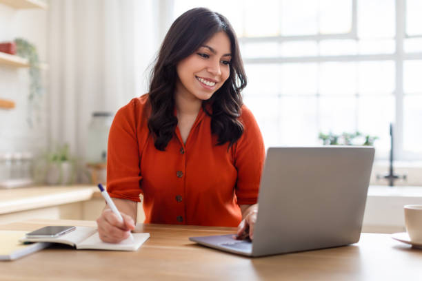 istock Content middle eastern woman working with laptop and notepad 2164499504